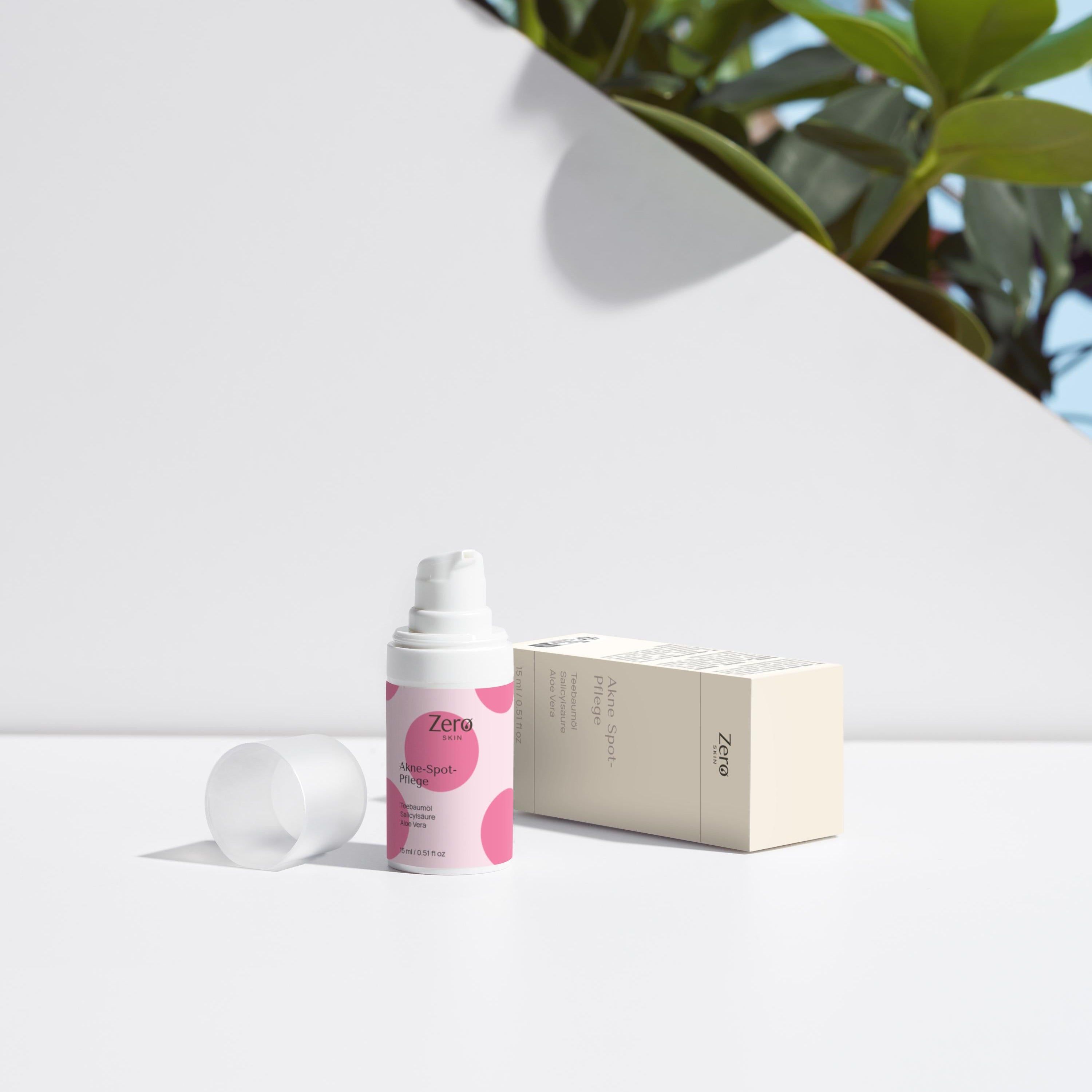 Weiße Pumpflasche mit rosa Kreisen und weißem Deckel daneben. Beige Verpackung mit Text.