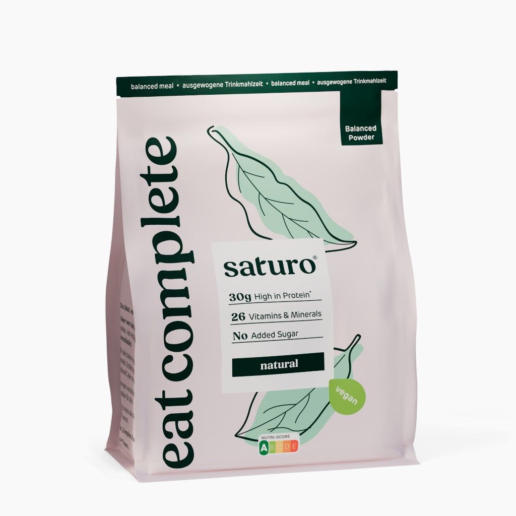 Beutel mit Saturo Trinkmahlzeit. Aufdruck: 30g Protein, 26 Vitamine & Mineralien, ohne Zuckerzusatz. Vegan. Grün-weiße Verpackung.