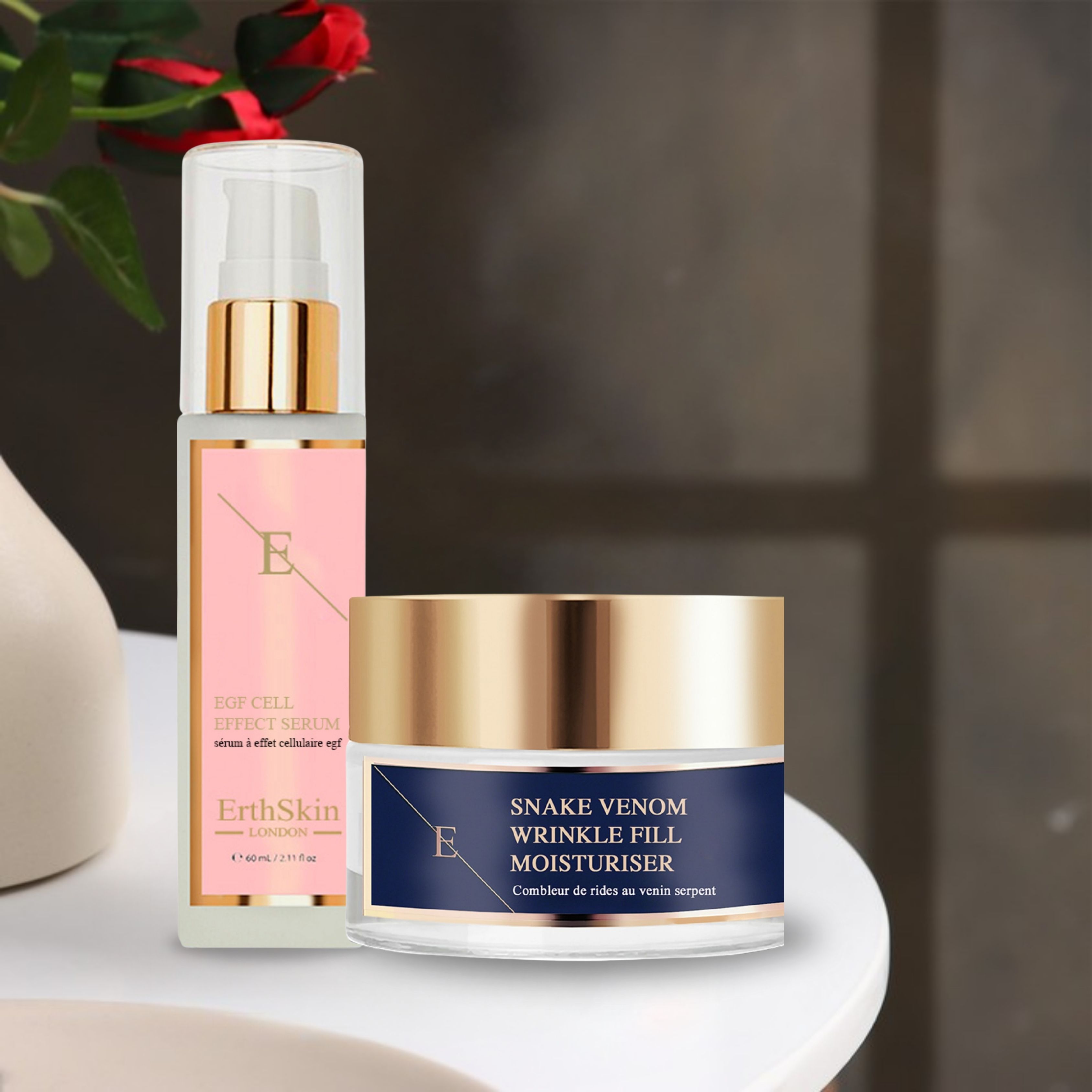 Creme- und Serum-Set. Creme-Tiegel mit goldfarbenem Deckel, Serum-Flasche mit Pumpe. Beide auf weißer Oberfläche.