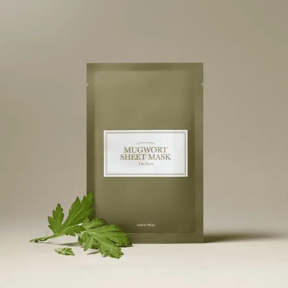 Grüne Sheet Maske mit weißem Etikett. Text: MUGWORT SHEET MASK, I'm from. Daneben ein Blatt.