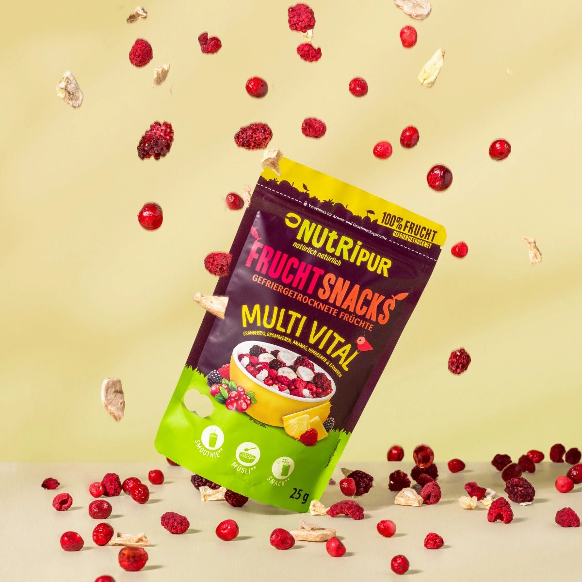 Tüte NutriPur Frucht Snacks, umgeben von gefriergetrockneten Früchten. Aufschrift: Multi Vital, 25g.