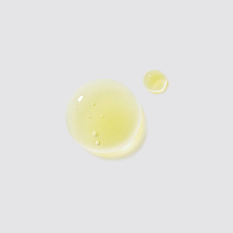 Zwei Tropfen Serum auf hellem Hintergrund. Gelbe, transparente Flüssigkeit.