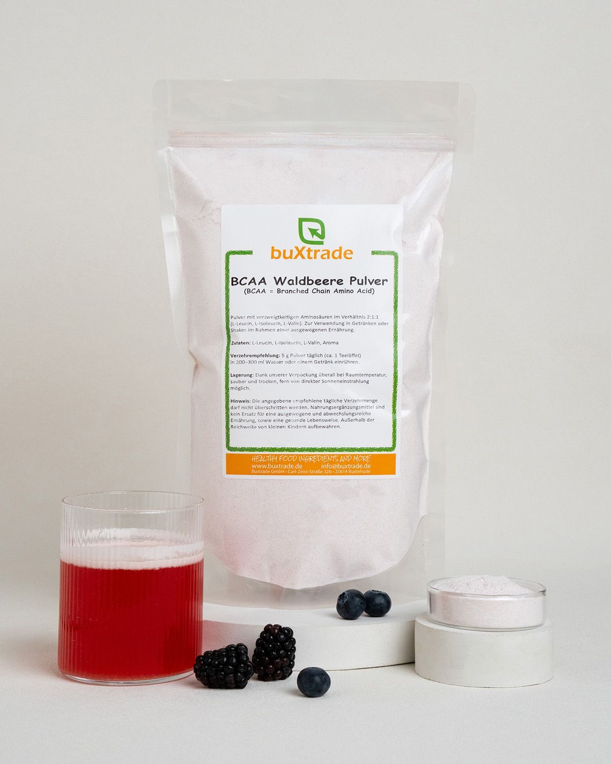 BCAA 2:1:1 Pulver Waldbeere von buXtrade in weißer Verpackung, daneben ein Glas Getränk und Beeren.