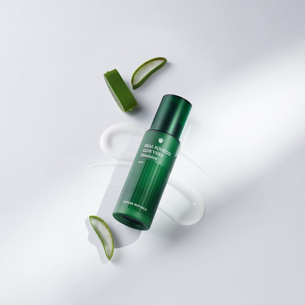 Grüne Flasche mit Aufschrift: REAL SQUEEZE ALOE VERA Emulsion, mit Aloe Vera Stücken und Creme.