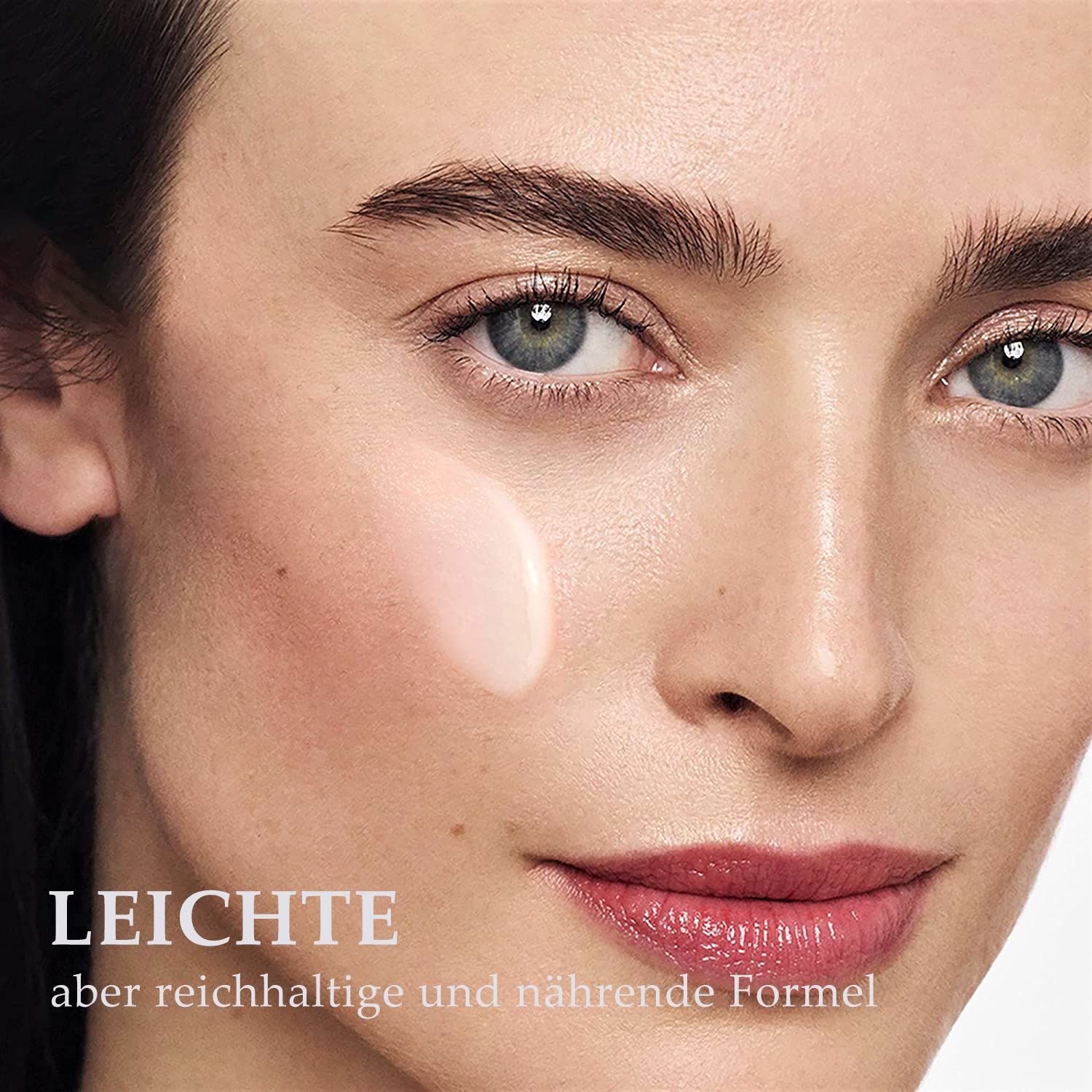 Nahaufnahme eines Gesichts mit Serum auf der Haut. Text: Leichte, aber reichhaltige und nährende Formel.