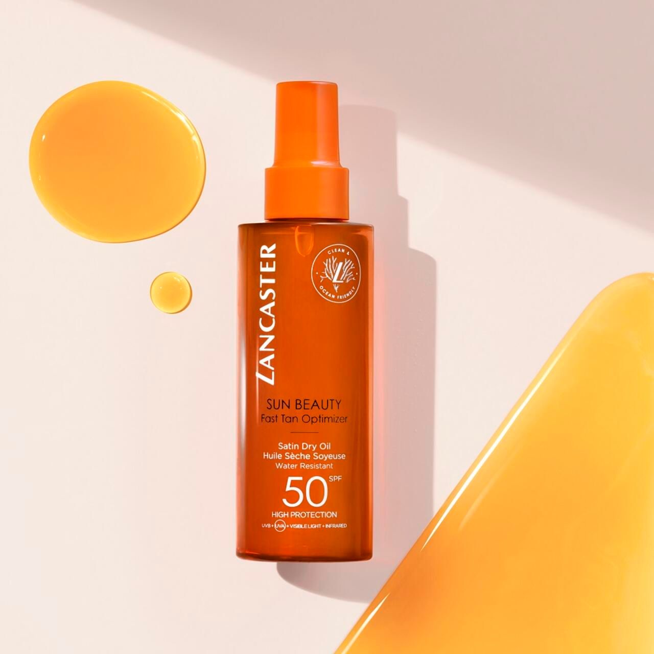 Lancaster Sun Beauty Dry Oil SPF50. Flasche und Tropfen. Text: Sun Beauty, Fast Tan Optimizer, Satin Dry Oil, 50 SPF.