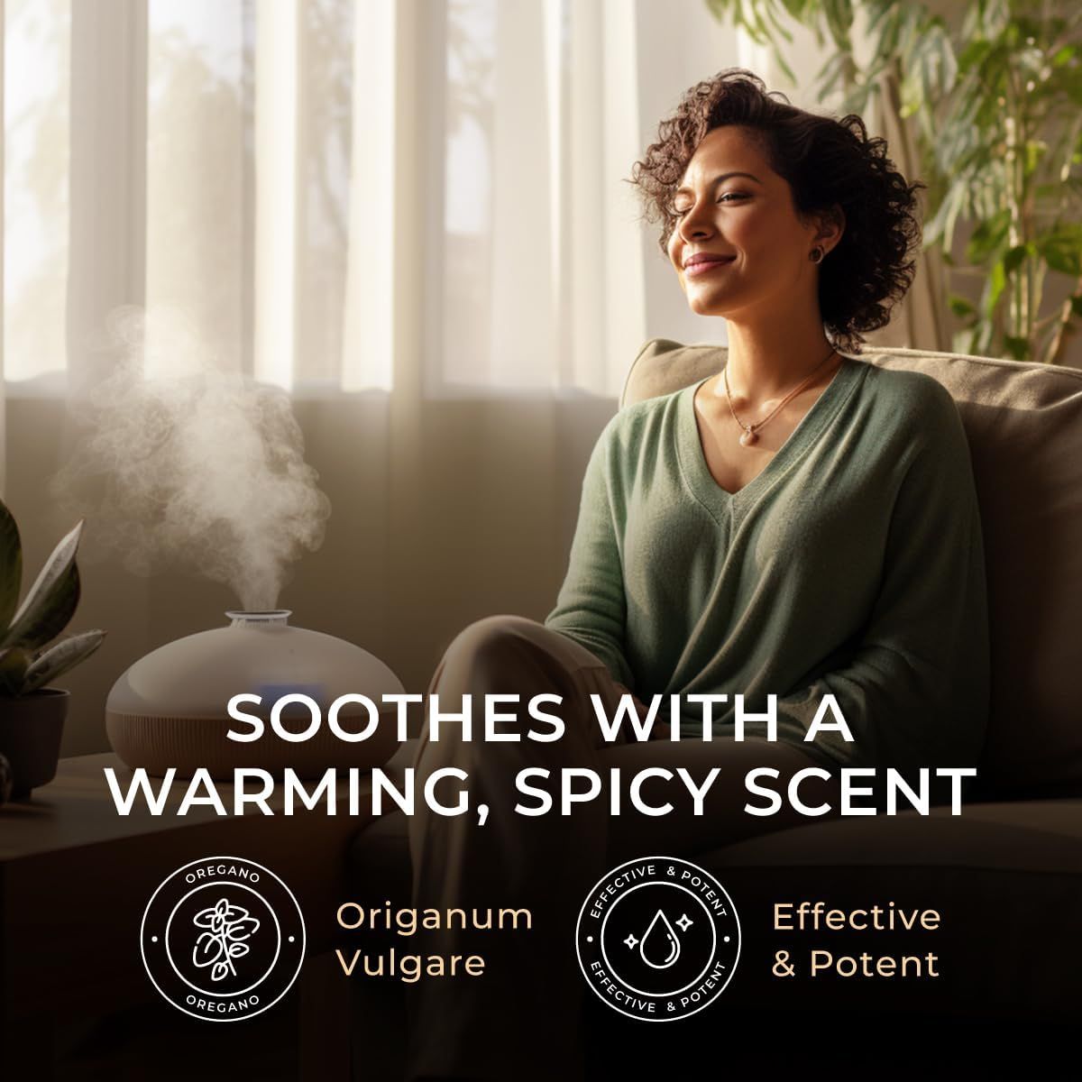 Eine Frau sitzt neben einem Diffusor. Der Diffusor verströmt Dampf. Text: Soothes with a warming, spicy scent. Logos: Oregano, Effective & Potent.