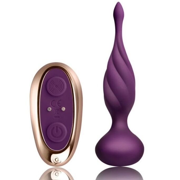 Lila Anal Stimulator mit gerilltem Design und breiter Basis, daneben eine Fernbedienung. Spiegelnde Oberfläche.