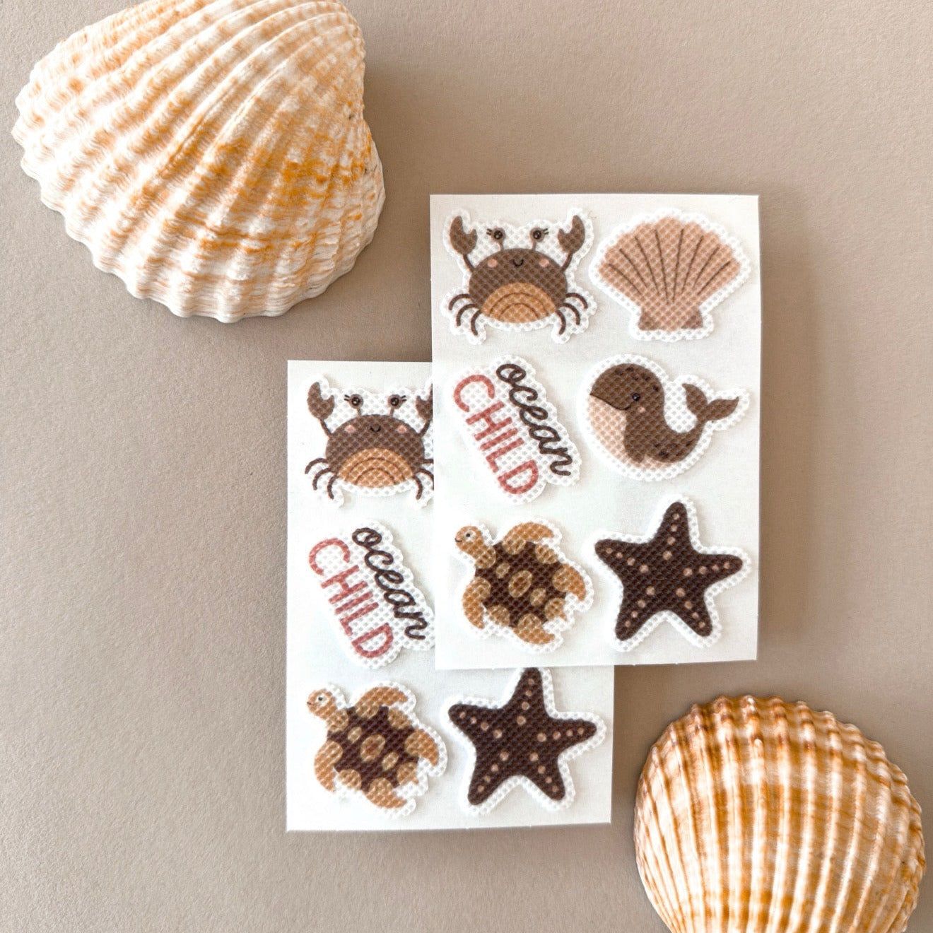 Zwei Stickerbögen mit Motiven wie Krabbe, Wal, Schildkröte und Seestern.