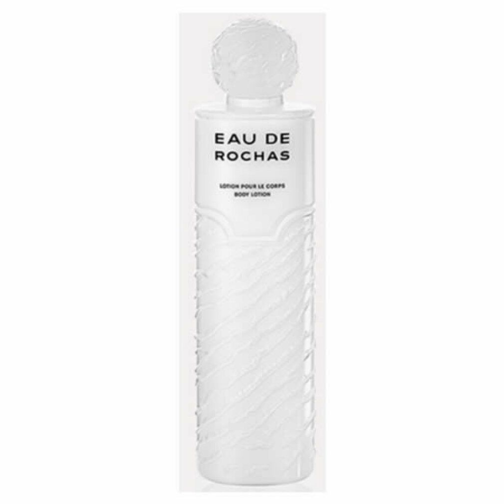 Weiße Flasche mit geriffelter Oberfläche. Oben steht "EAU DE ROCHAS". Darunter "LAIT PARFUMÉ POUR LE CORPS".