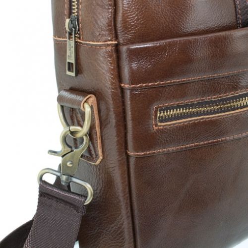 Nahaufnahme einer braunen Ledertasche mit Reißverschluss und Metallbeschlägen. Detailansicht.