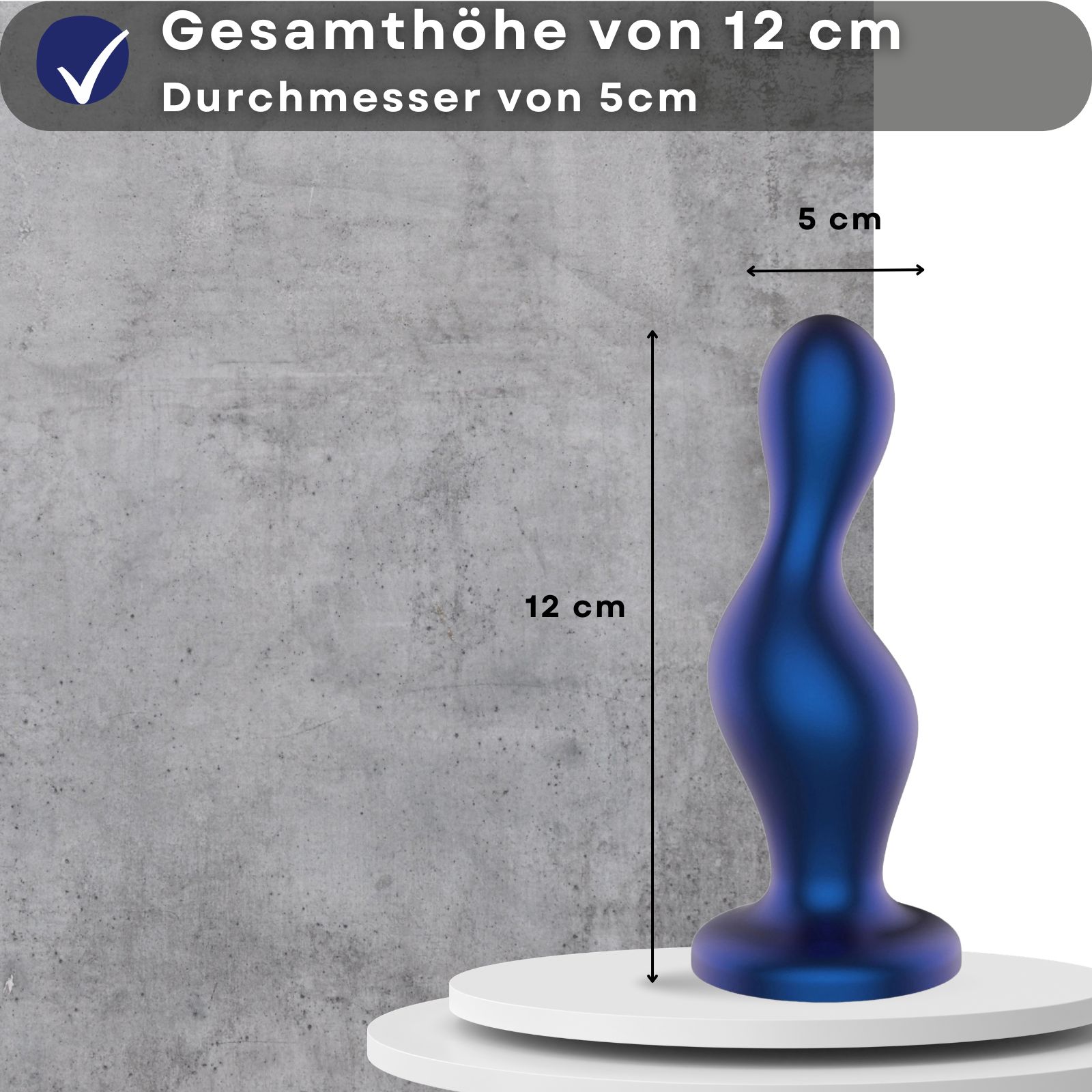 Blauer Analplug. 12 cm hoch, 5 cm Durchmesser. Auf Podest. Grauer Hintergrund.