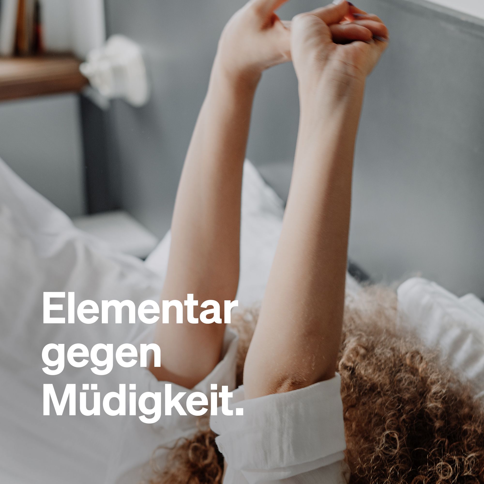 Person liegt im Bett, Arme nach oben gestreckt. Text: Elementar gegen Müdigkeit.