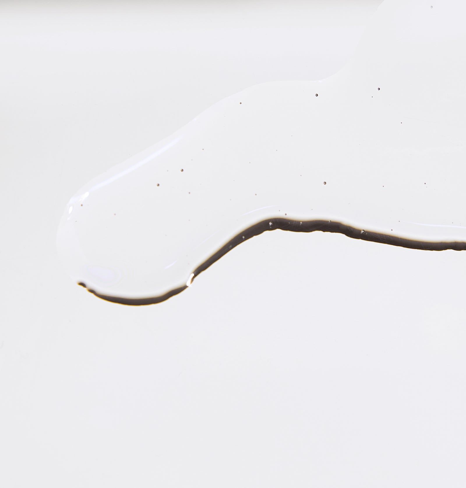 Weißes Serum auf weißem Hintergrund. Schwarze Linie am unteren Rand.