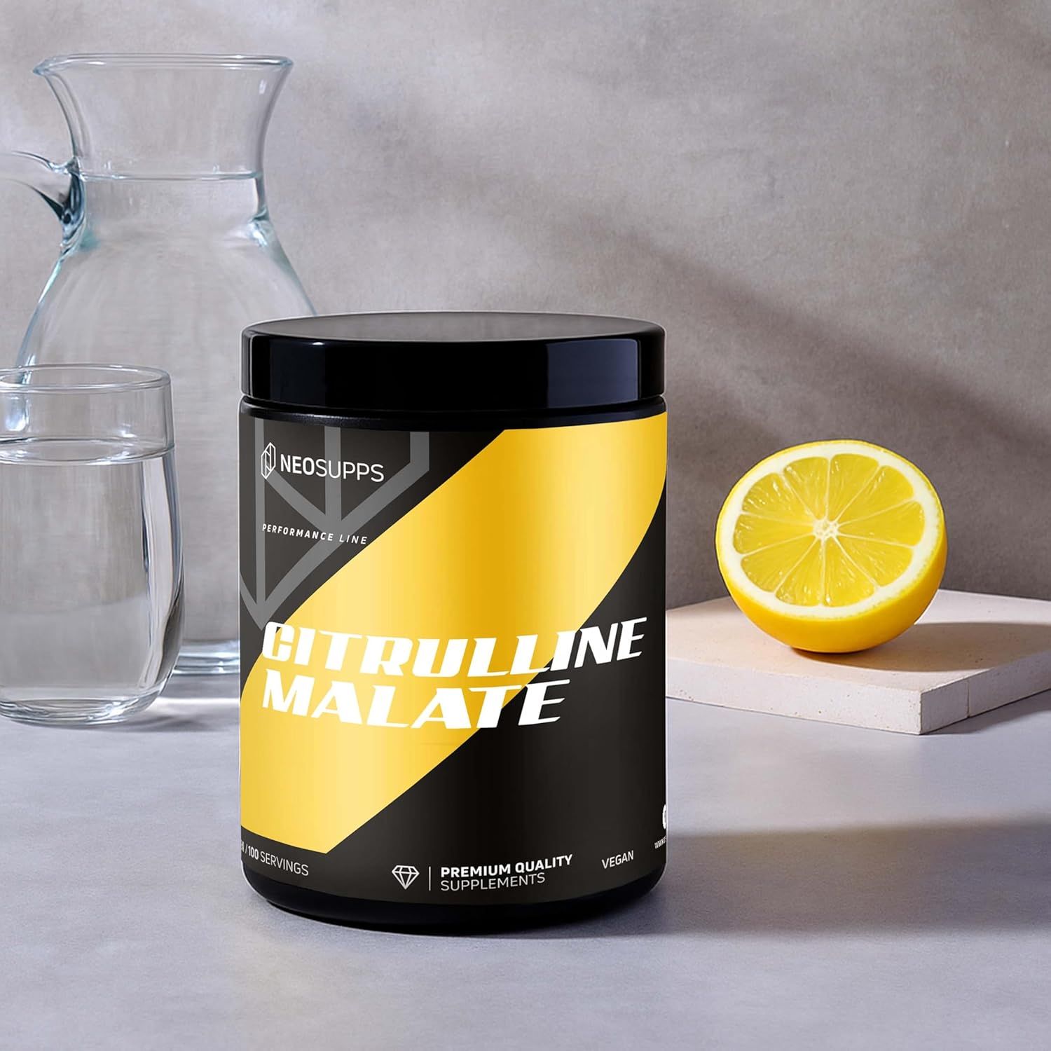Schwarze Dose mit gelbem Streifen, CITRULLINE MALATE Schriftzug. Zitrone und Glas mit Wasser daneben. Vegan, 100 Portionen.