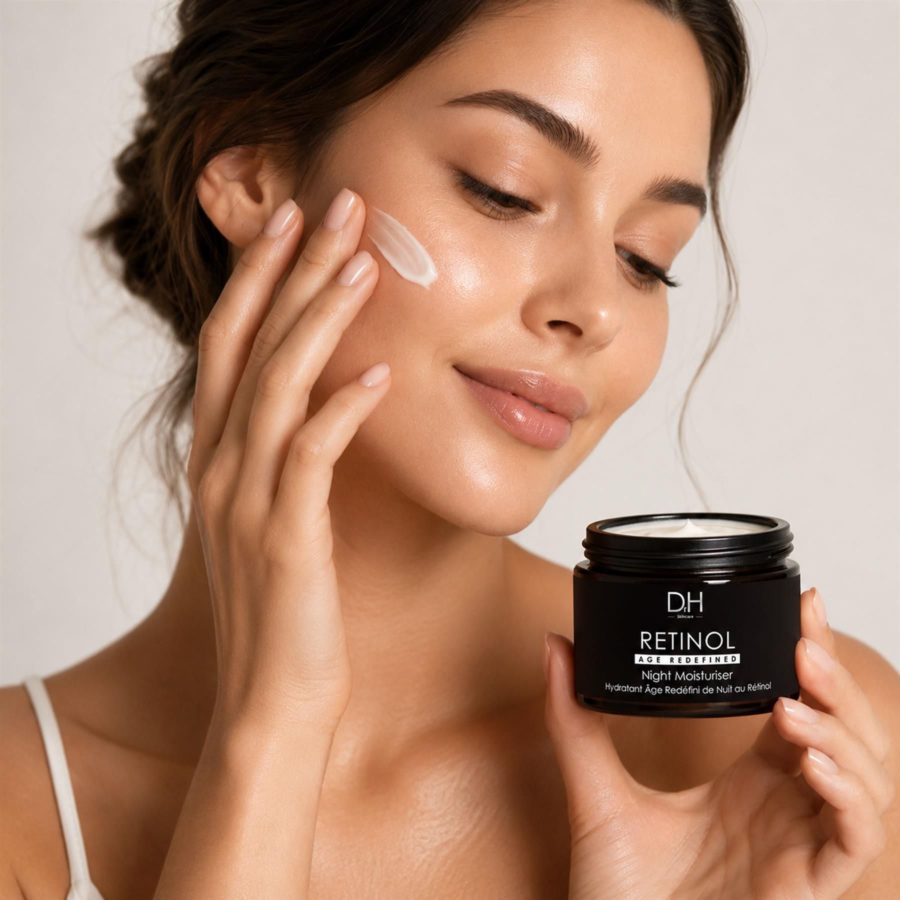 Frau trägt Dr H Retinol Age Redefined Nachtcreme auf ihr Gesicht auf.