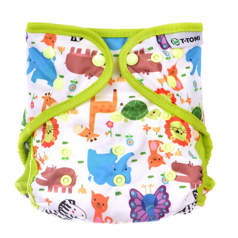 T-TOMI Überunterhose ZOO. Weiße Stoffwindel mit bunten Tierfiguren. Grüne Einfassung und Druckknöpfe. T-TOMI Logo.