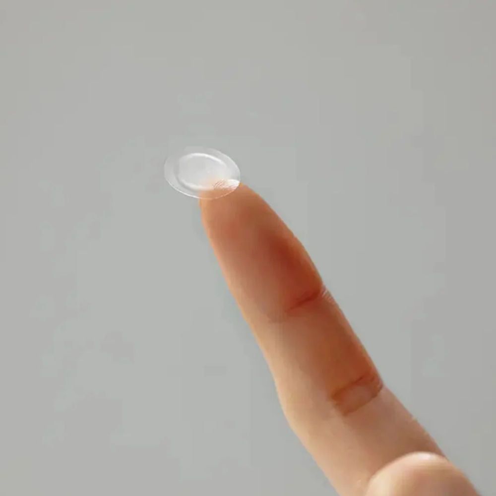 Transparenter, runder Patch auf einem Finger. Der Patch ist leicht gewölbt.
