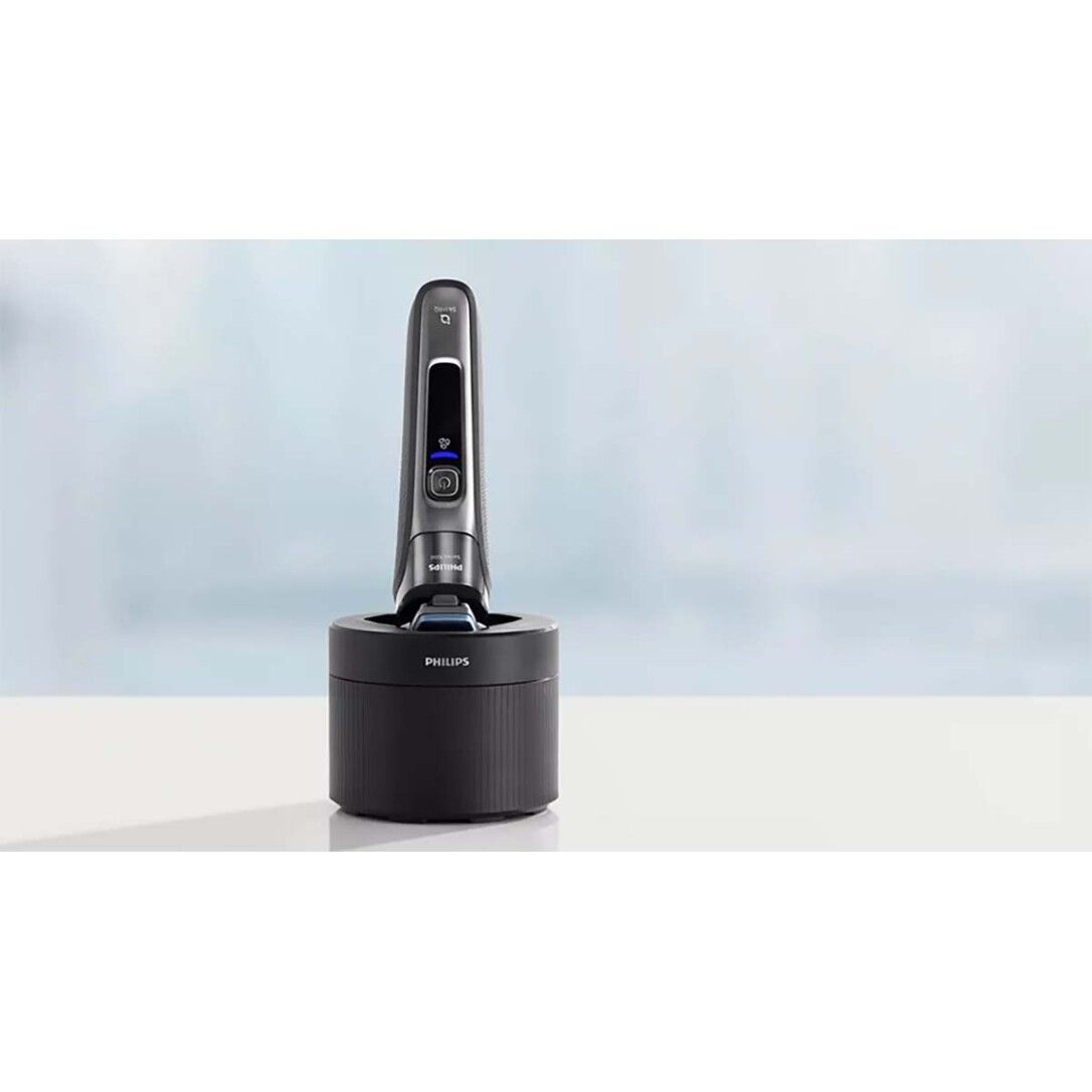 Rasierer in einer schwarzen Basis. Der Rasierer ist silberfarben mit einem Display. Der Name Philips ist sichtbar.