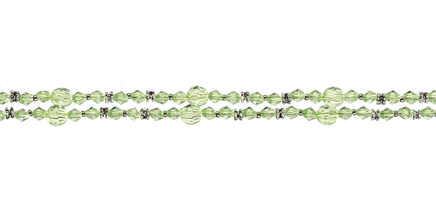 Nahaufnahme einer Brillenkette mit grünen Perlen und silberfarbenen Elementen. Die Kette ist horizontal angeordnet.