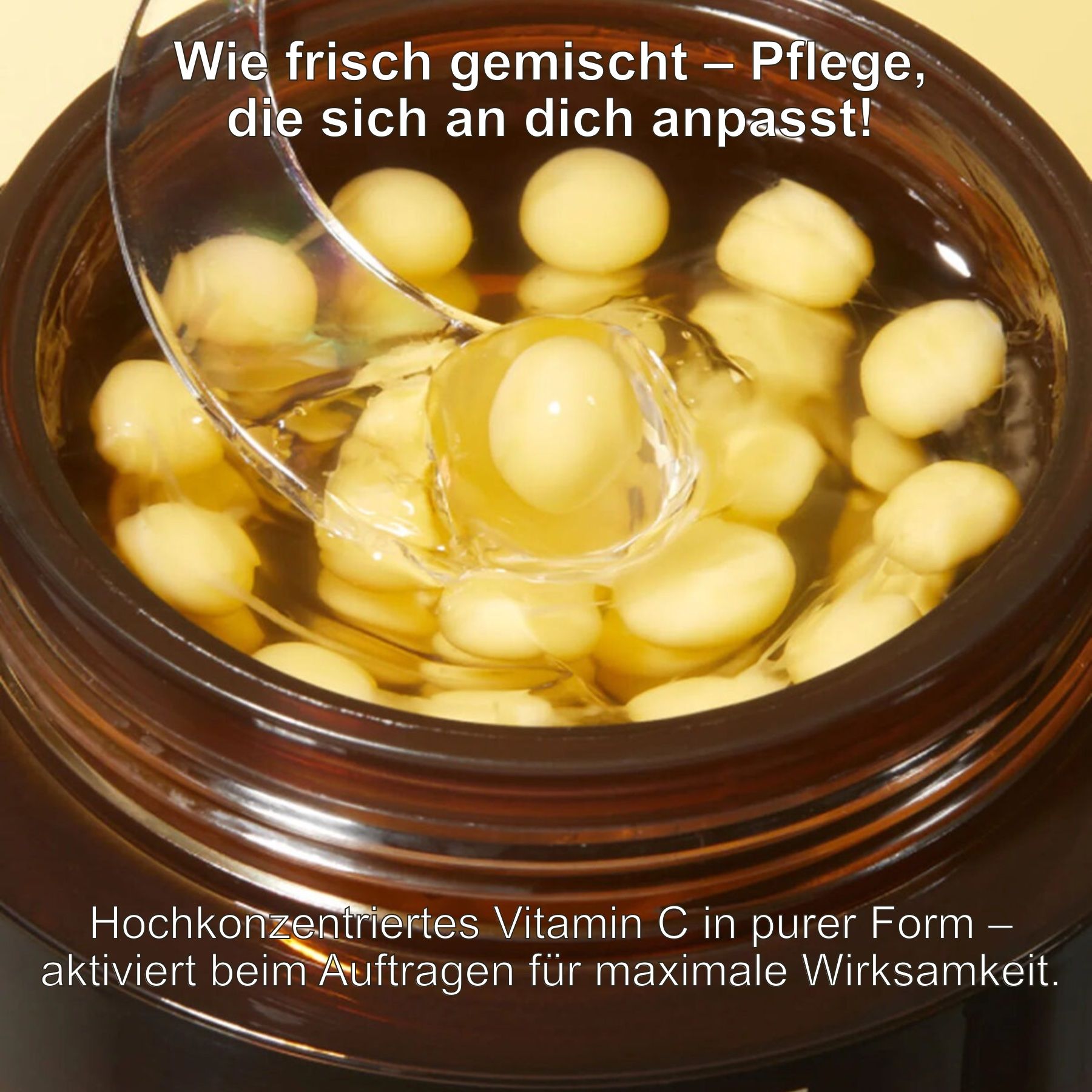 Geöffneter Tiegel mit Creme und gelben Kapseln. Löffel mit Kapsel. Text: Hochkonzentriertes Vitamin C in reiner Form.
