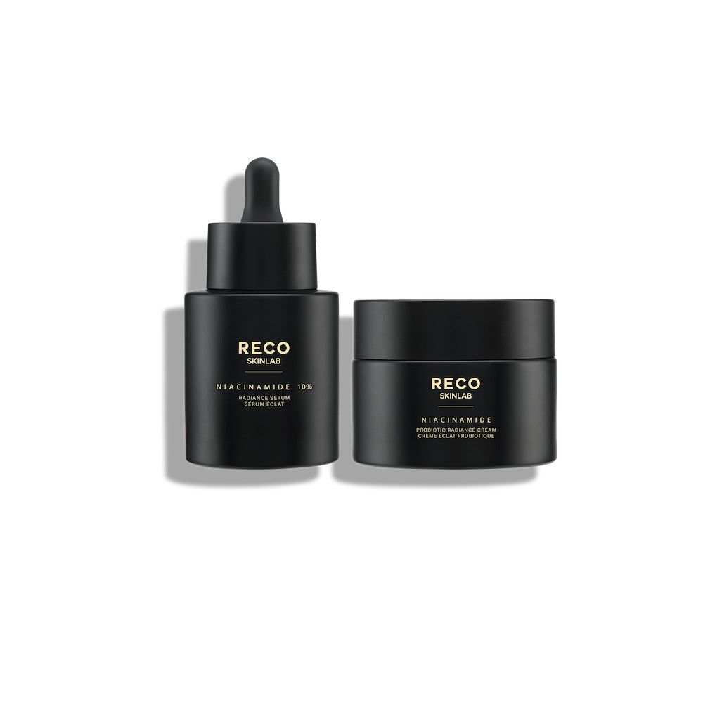 Zwei schwarze Flakons. Links: Serumflakon mit Pipette. Rechts: Tiegel. Beide mit goldfarbenem Text: RECO SKINLAB, Niacinamide 10%.