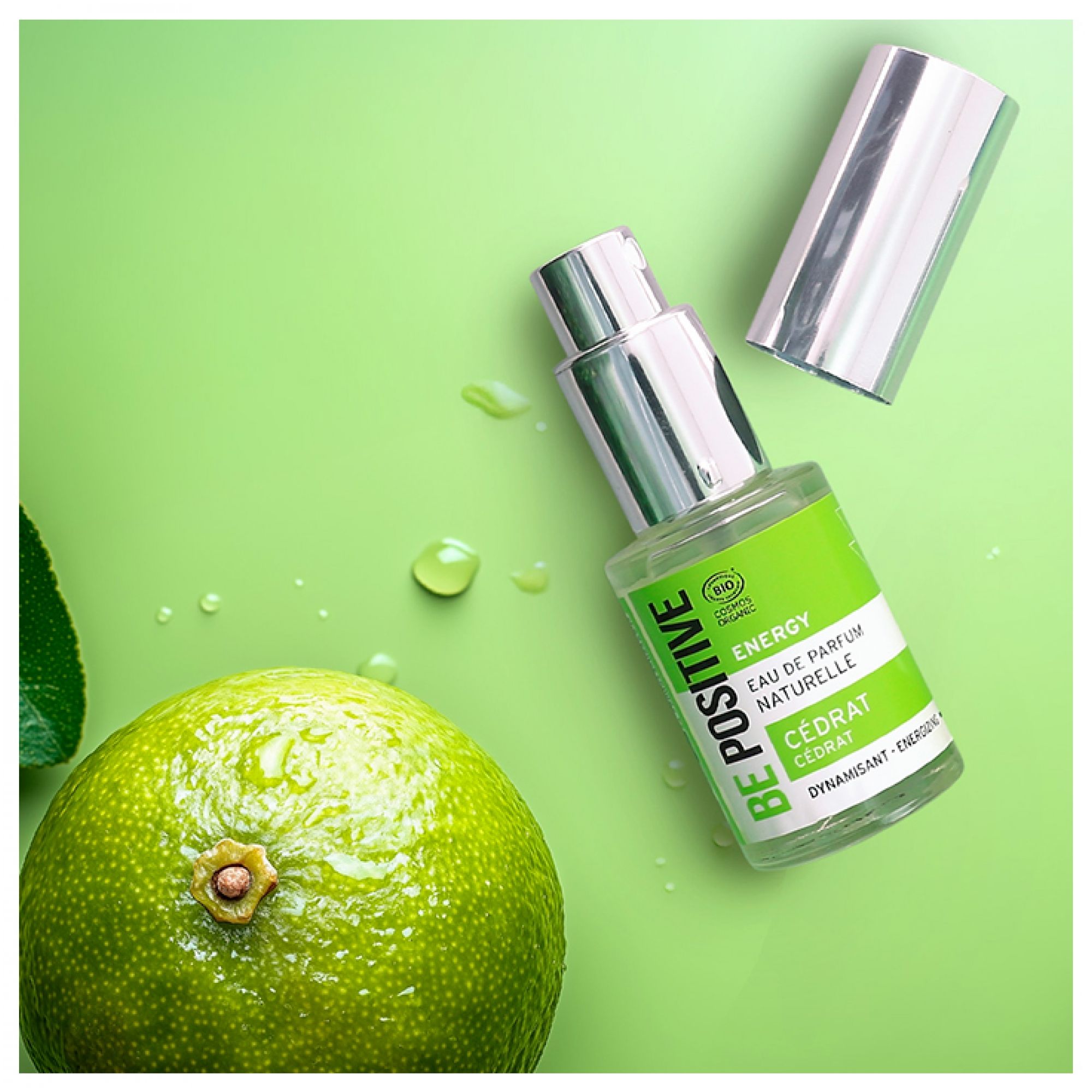 Acorelle Be Positive EdP Energy Cedrat Eau de Parfum Flakon neben einer Zitrone auf grünem Hintergrund.