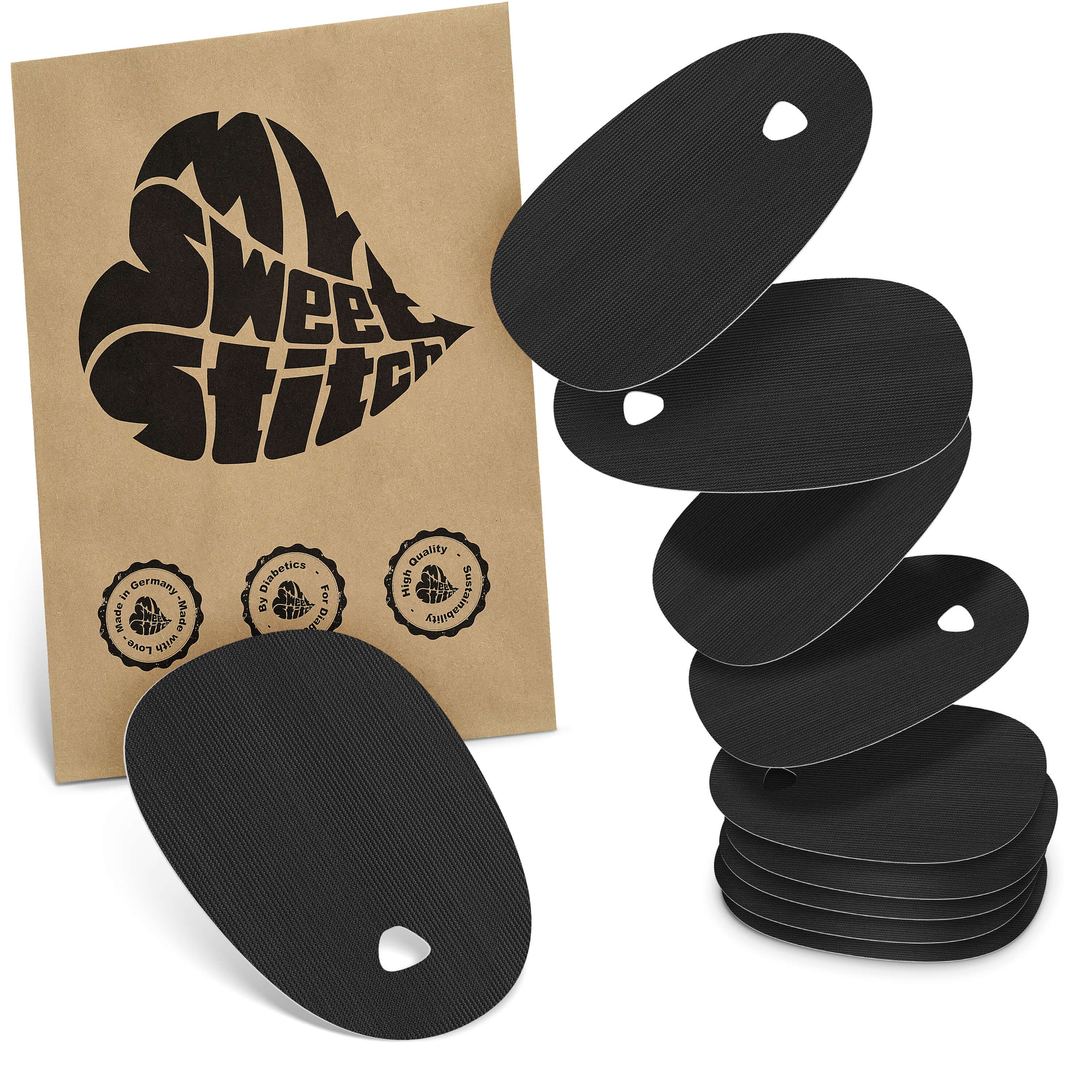 Schwarze, ovale Pflaster mit Loch. Neben einer braunen Verpackung mit Logo und Qualitätssiegeln. Mehrere Pflaster gestapelt.