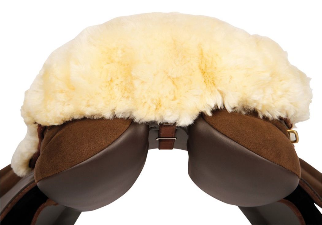 Beiger Lammfell Sattelsitzbezug auf einem braunen Sattel. Ansicht von vorne.