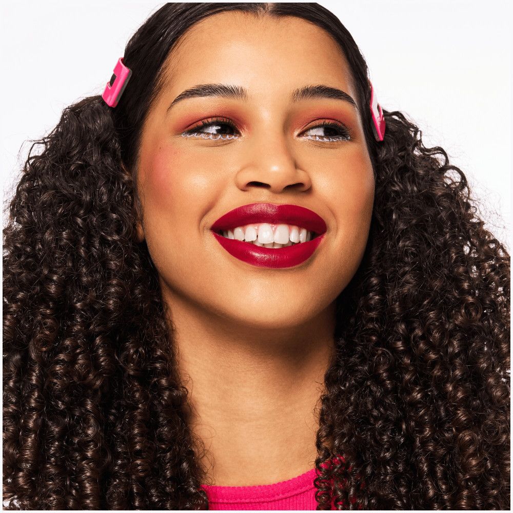 Porträt einer lächelnden Frau mit rotem Lippenstift und Rouge.