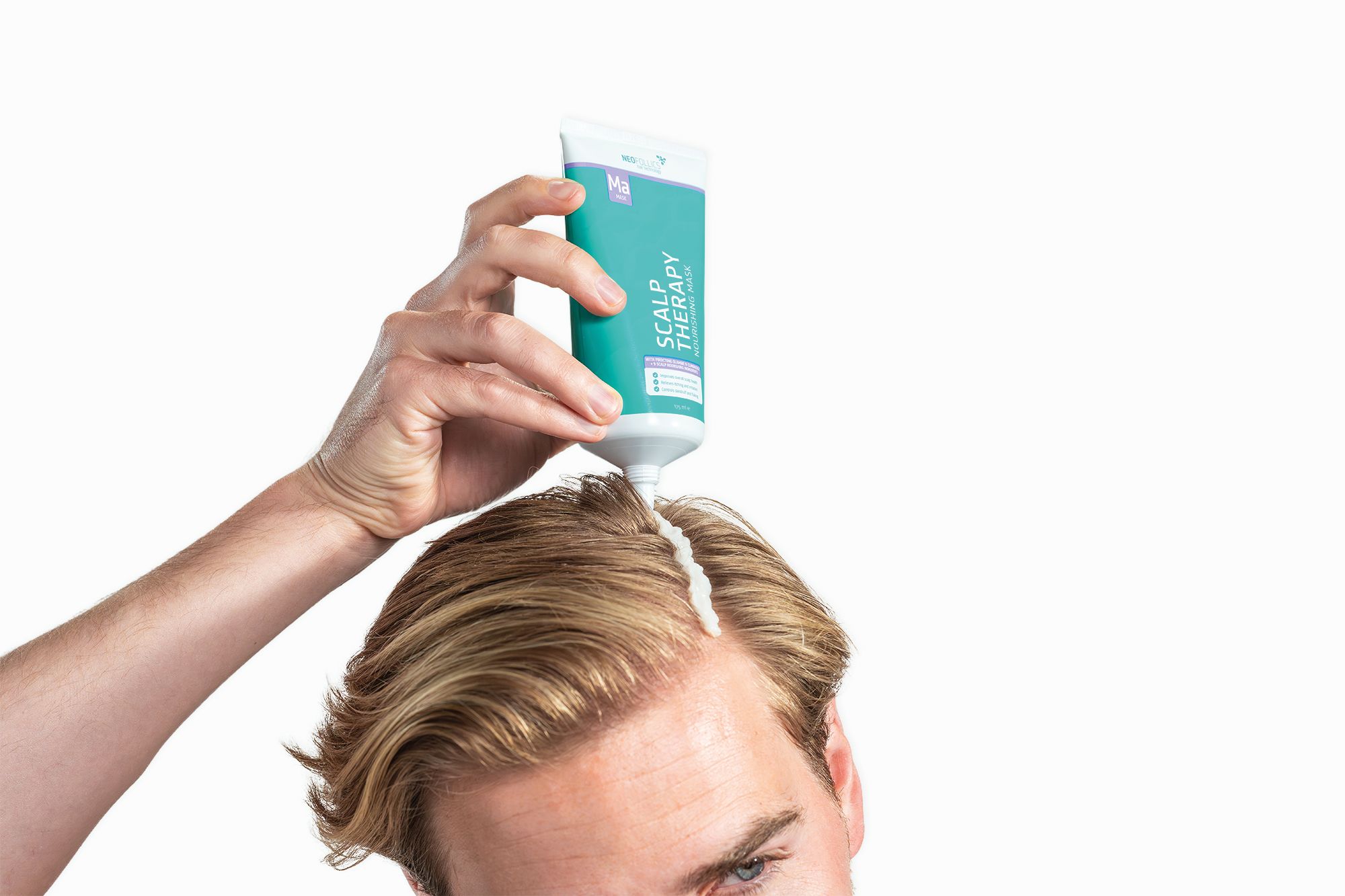 Hand drückt eine Tube mit der Aufschrift "SCALP THERAPY" aus, um eine weiße Creme auf den Scheitel eines Mannes aufzutragen.