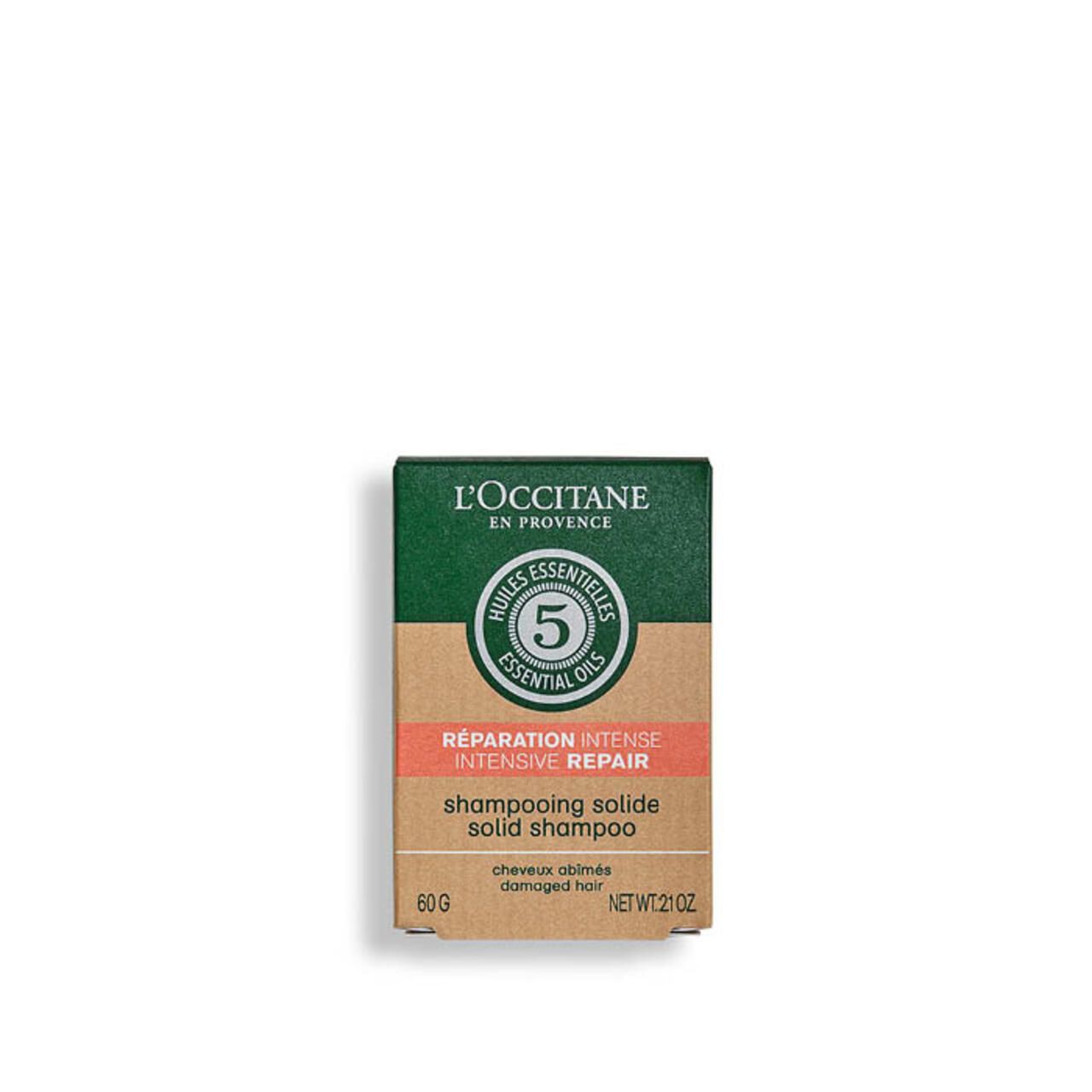 Kartonverpackung. Aufschrift: L'Occitane, Huiles Essentielles, 5, Réparation Intense, Shampooing Solide, 60g, damaged hair.