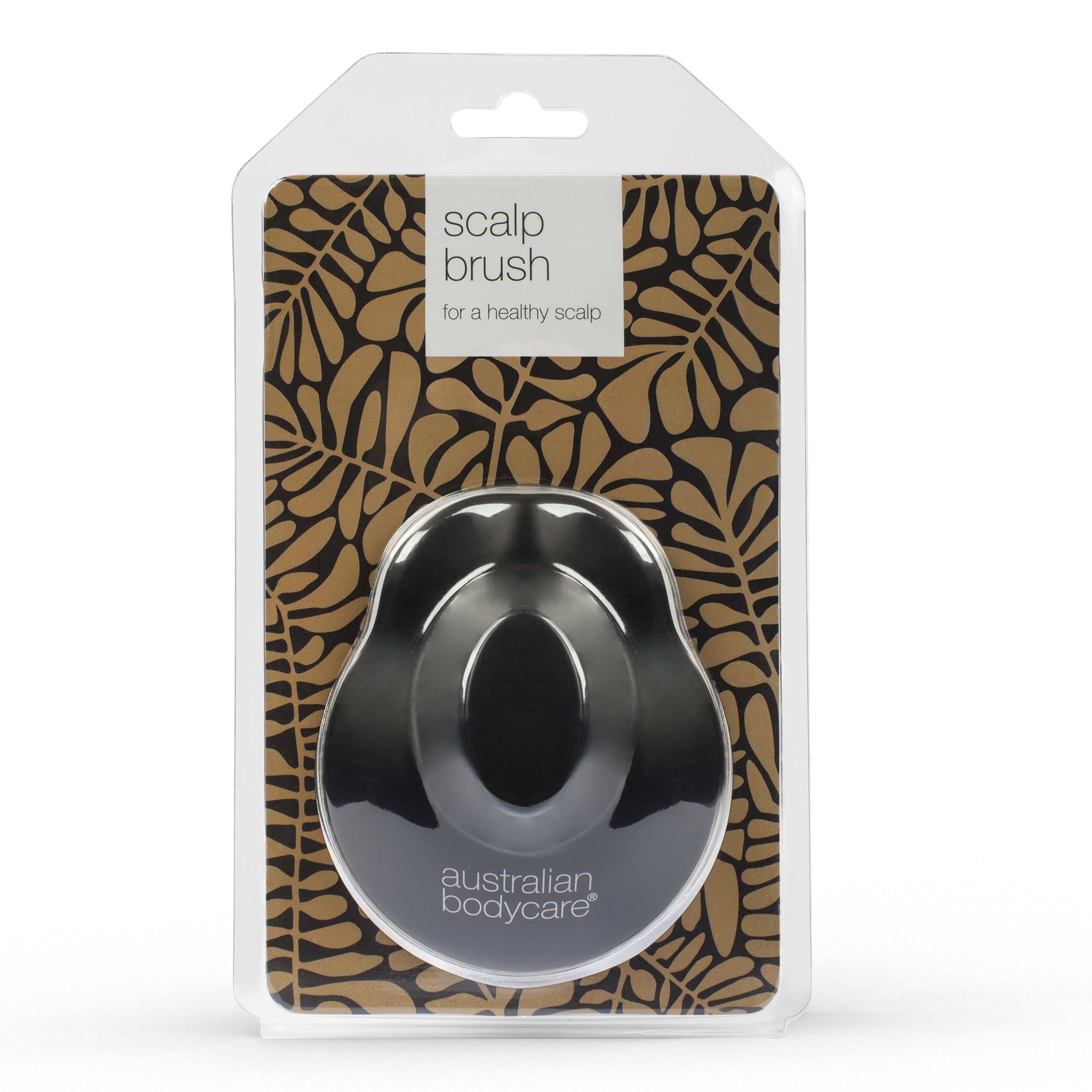 Schwarze Kopfmassagebürste in Blisterverpackung. Aufschrift: „scalp brush for a healthy scalp“ und „australian bodycare“.