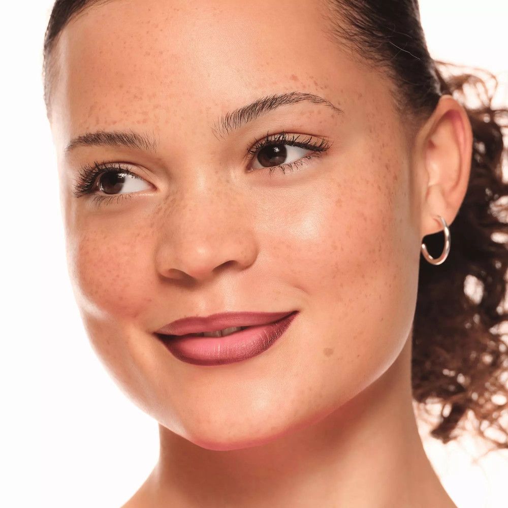 Frau mit Lippenstift. Dunkelbraune Lippen. Haut mit Sommersprossen.