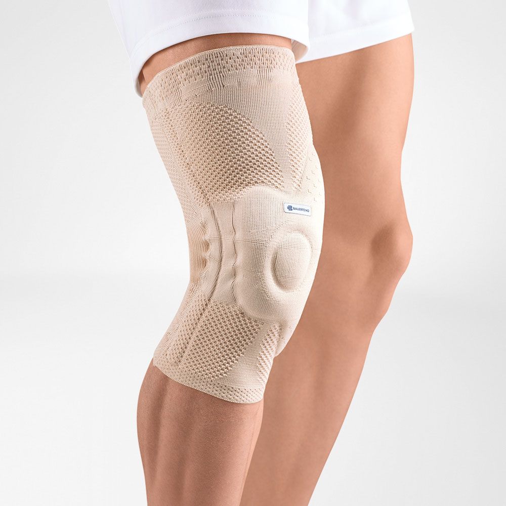 Beige Kniebandage. Gestricktes Material, anatomische Form. Mit Patella-Aussparung und seitlichen Stabilisatoren.