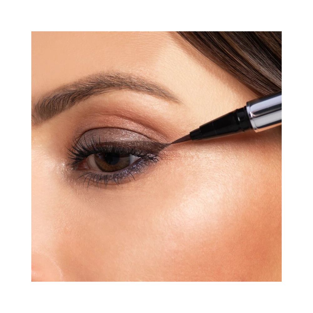 Nahaufnahme eines Auges, das mit schwarzem Eyeliner geschminkt wird. Dunkle Lidschatten.