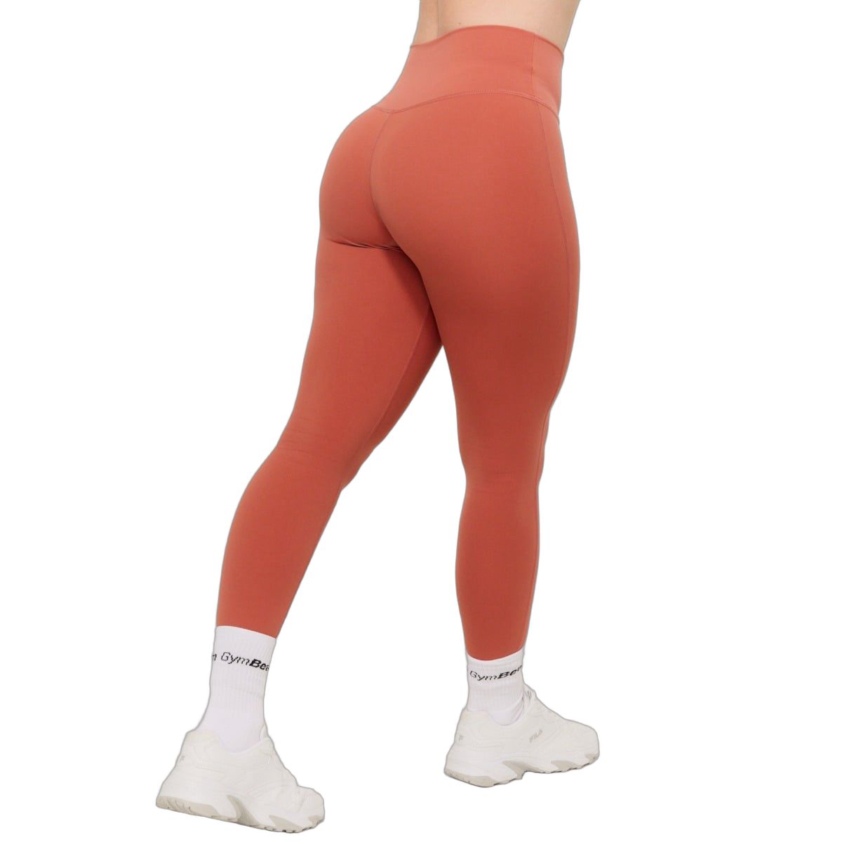 Rückansicht einer Frau in knöchellangen, zimtfarbenen Leggings mit hohem Bund und ohne vordere Naht.