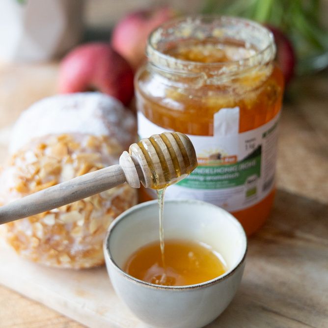 Glas Honig mit Etikett, Honigheber und Schale. Aufschrift: BIO-Lavendelhonig (roh).