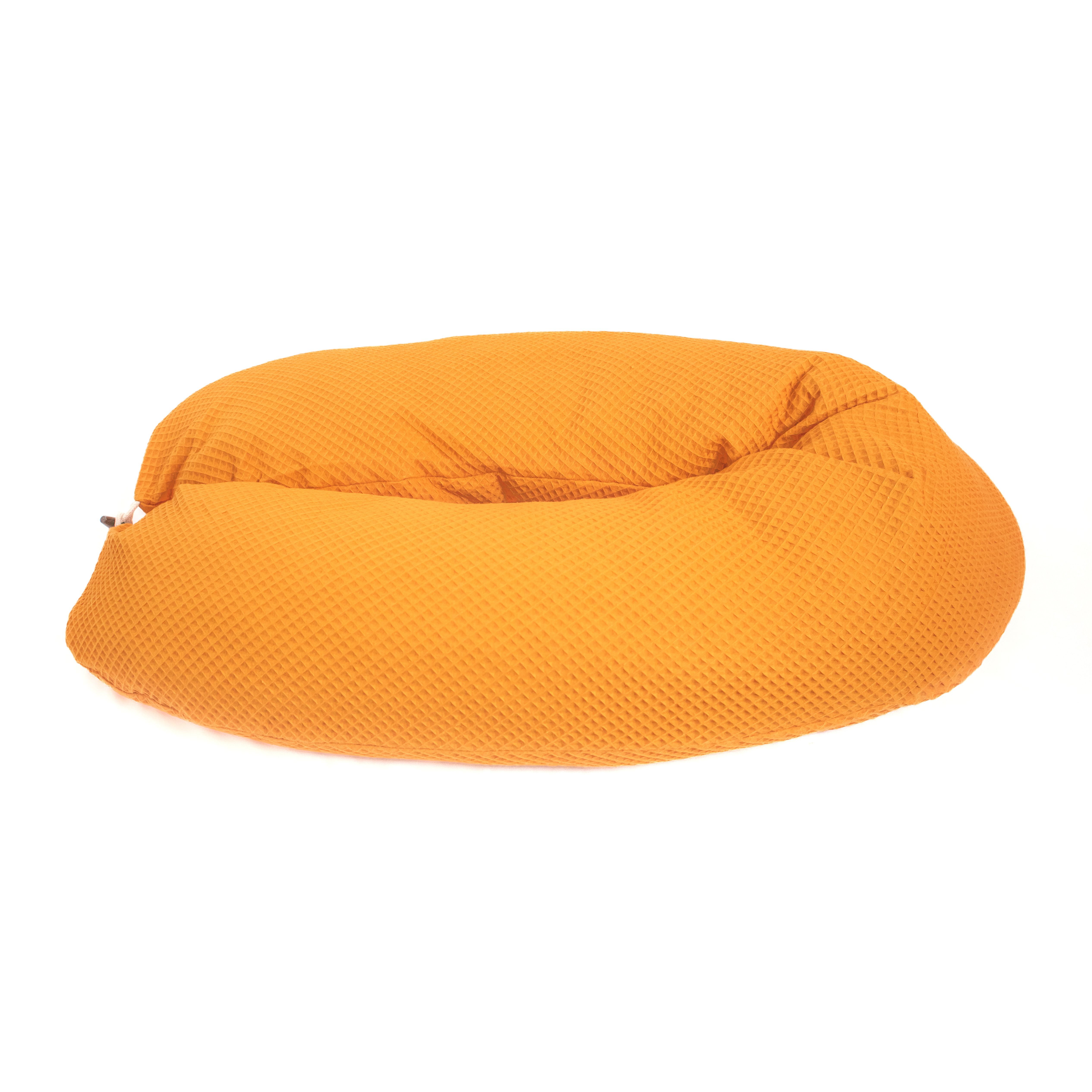 Senffarbenes Seitenschläferkissen aus Waffelstoff. Oval geformt.