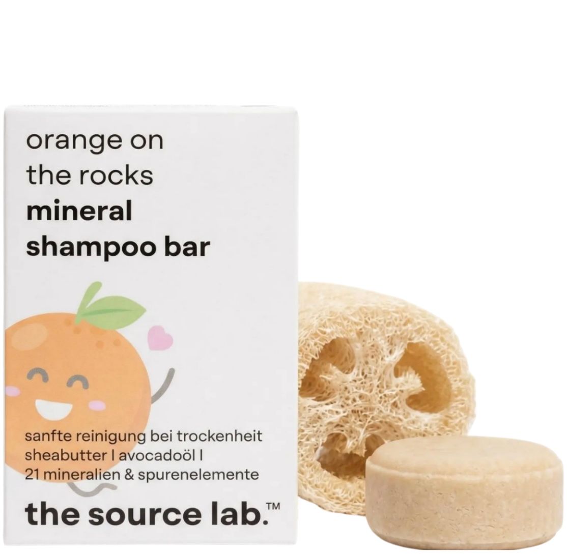 Verpackung mit Shampoo-Bar und Seifenkissen. Aufschrift: orange on the rocks mineral shampoo bar. Text: sanfte Reinigung bei Trockenheit. the source lab.