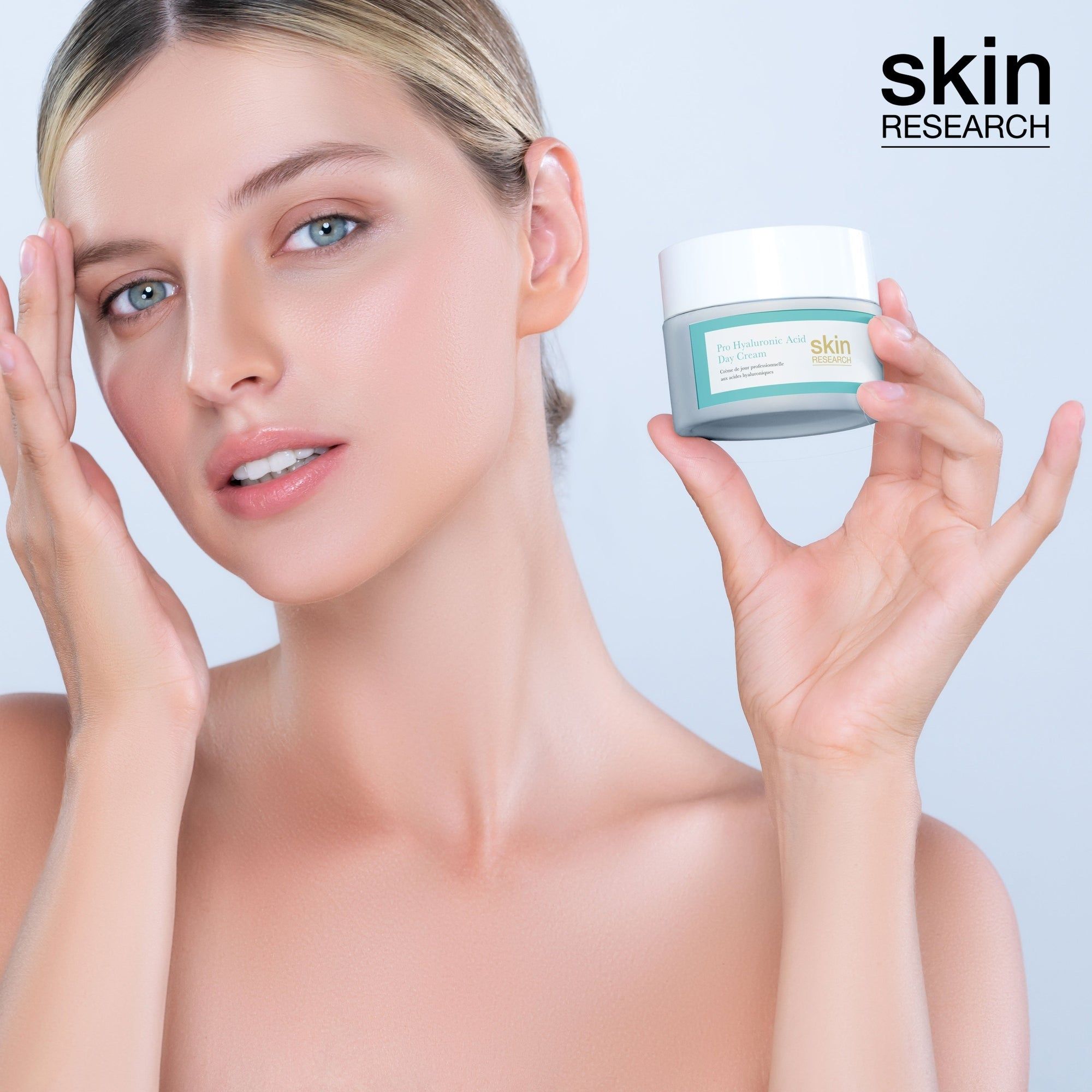Frau hält ein Creme-Glas. Aufschrift: Pro Hyaluronsäure Tagescreme. Marke: skin RESEARCH. Helle Haut.