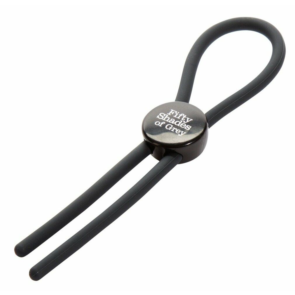 Schwarzer Love Ring mit Logo Fifty Shades of Grey, gehalten von einer Hand. Zwei Stränge gehen nach unten.