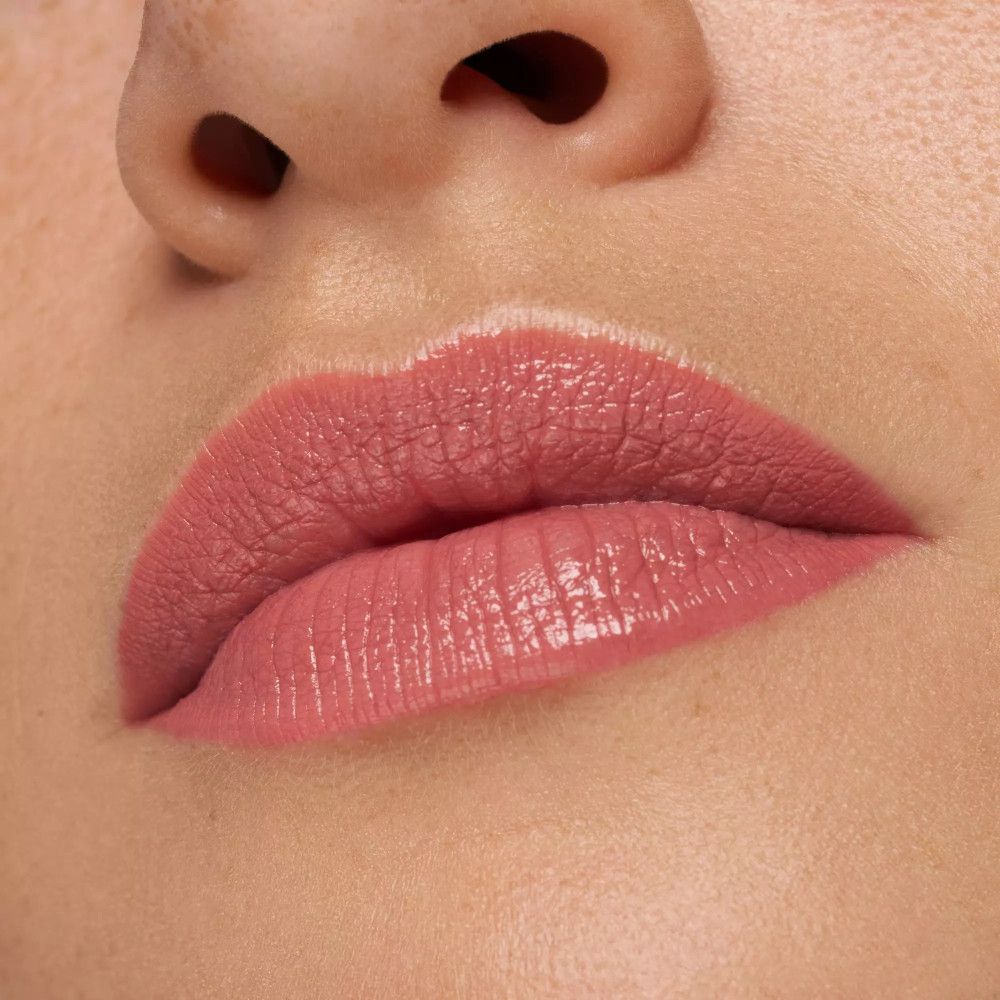Nahaufnahme von Lippen. Lippenstift in Rosa aufgetragen. Glänzendes Finish.