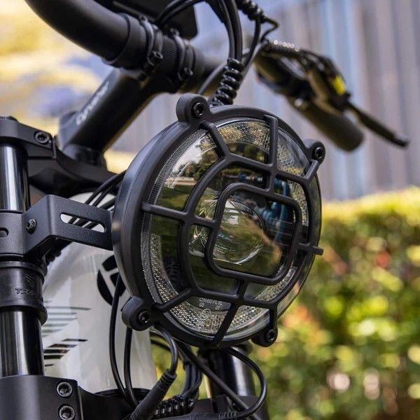 Runder Frontscheinwerfer mit Schutzgitter am E-Bike. Schwarzes Gehäuse, klare Linse.