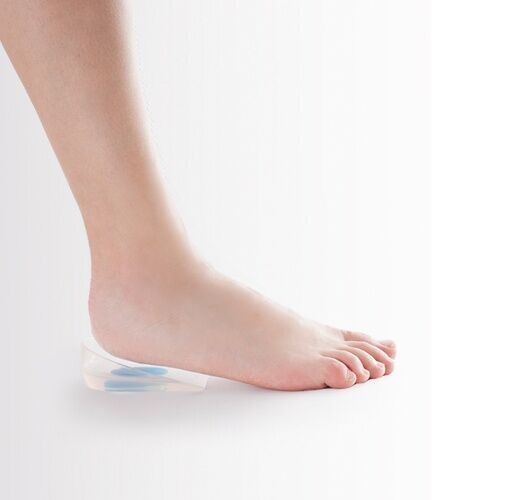 Fuß auf transparentem Fersenkissen mit blauem Einsatz. Seitenansicht, zeigt die Anwendung.