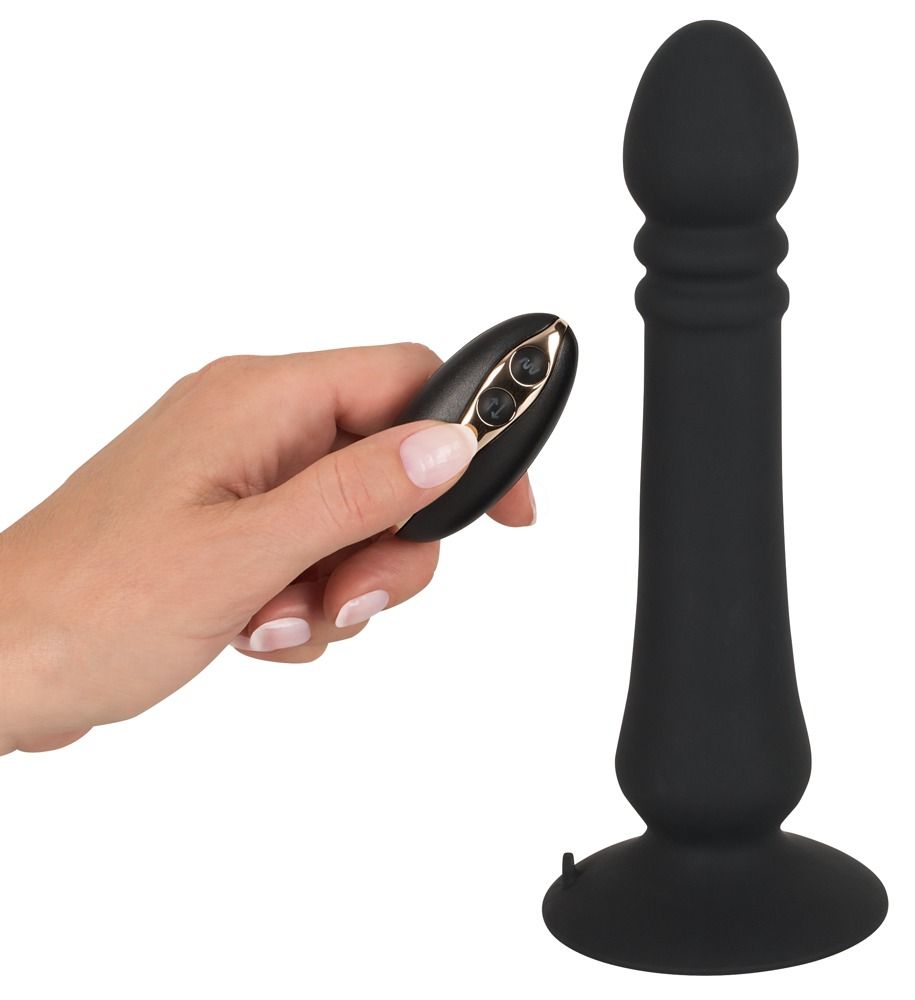 Schwarzer Anal Thruster und Fernbedienung, gehalten von einer Hand. Aus Silikon. Konische Form.