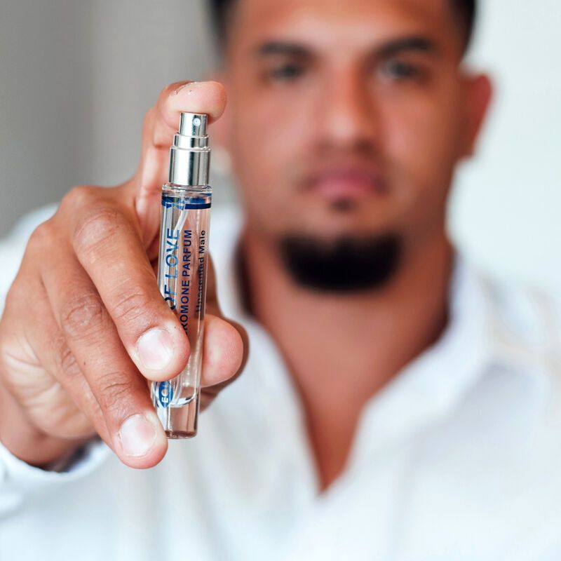 Ein Mann hält einen Flakon des "Eye of Love" Pheromon-Sprays für Männer, geruchlos.