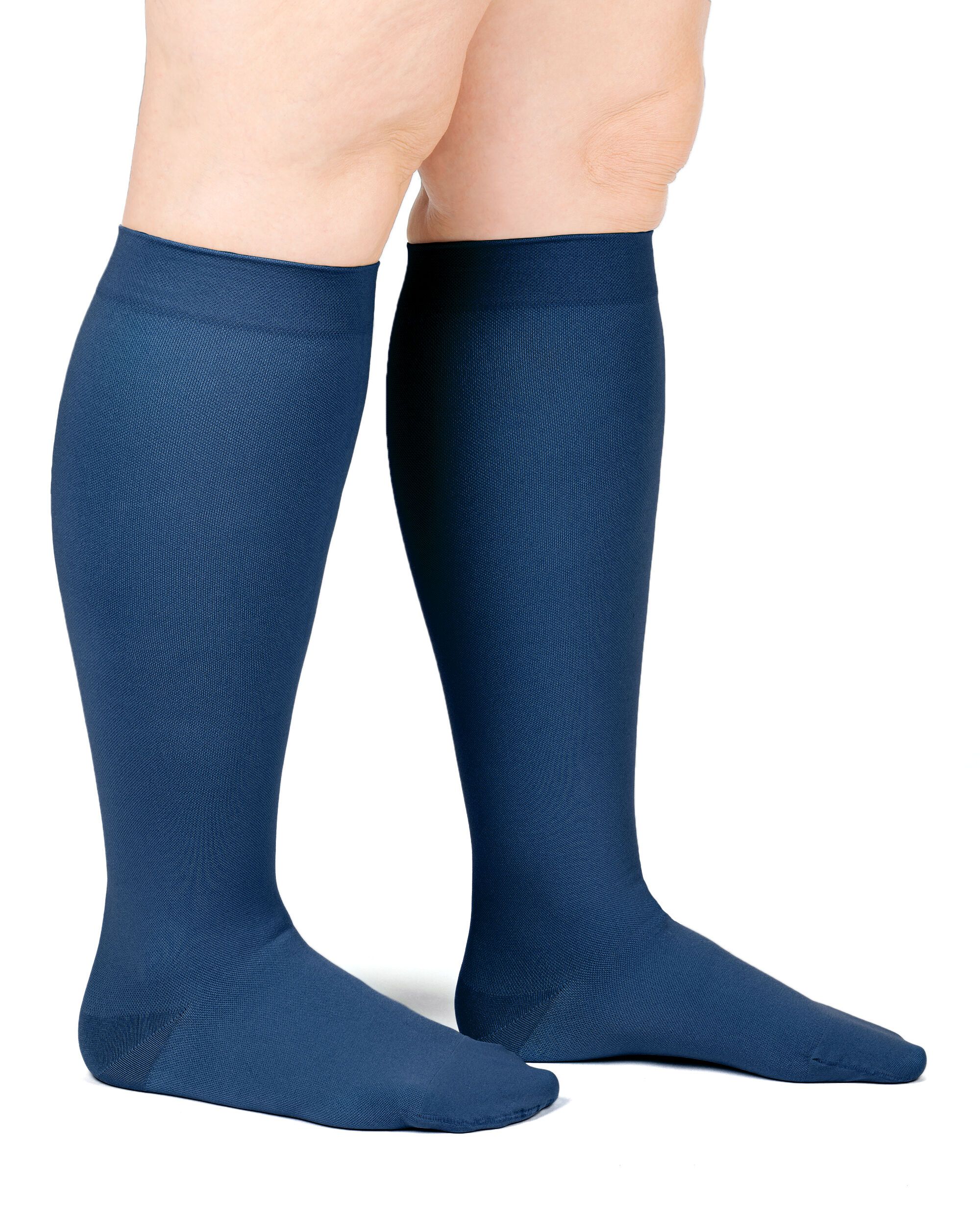 Beine mit dunkelblauen Kompressionsstrümpfen. Kniestrümpfe. Glatter Stoff.