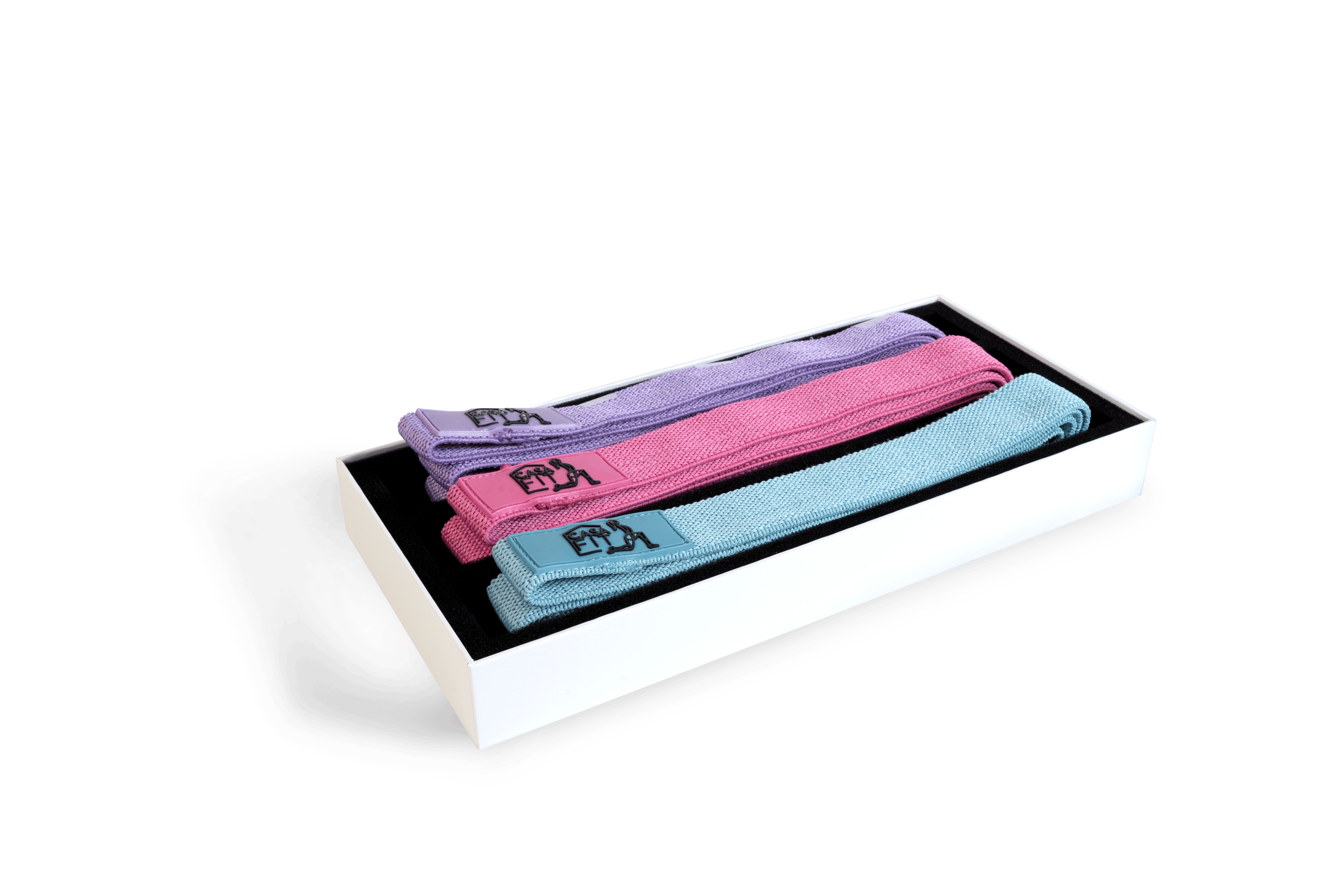 Drei Stoff-Widerstandsbänder in Pastelltönen (Hellblau, Rosa, Lila) liegen in einer weißen Geschenkbox.