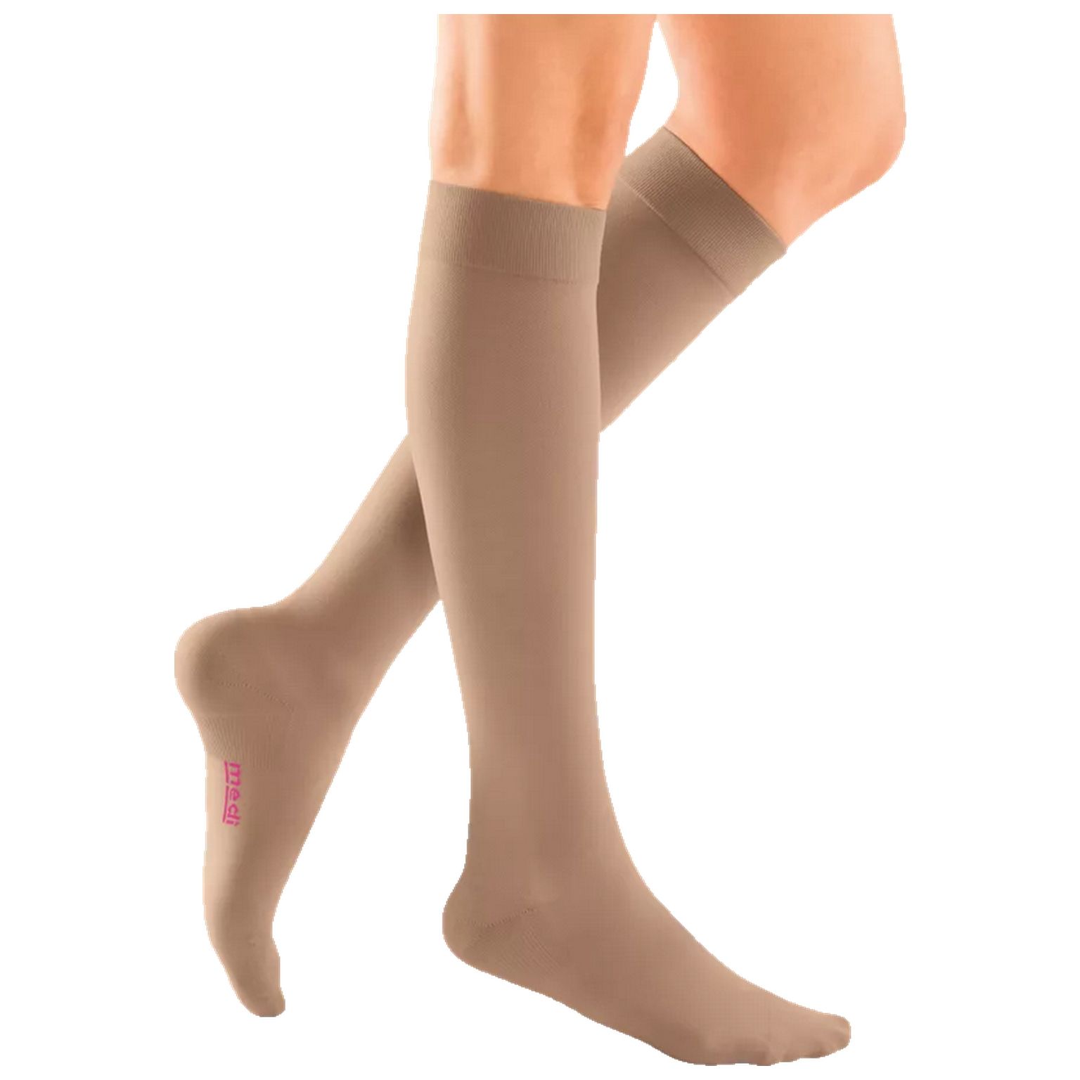 Beige Kompressions-Kniestrümpfe an Beinen. Rosa Logo am Fuß. Blick von der Seite.